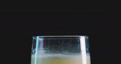 Fizzy refreshing drink in a glass against a black background