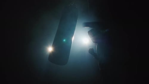 Boxer Trains in the Spotlight Beats a Boxing Pear