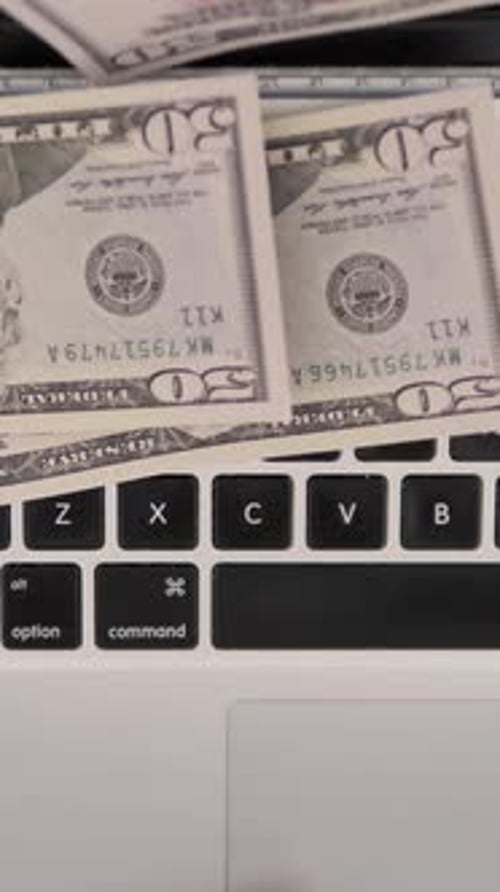 Top View of Dollars Falling on Keybord of Laptop, Rain, Vertical Video