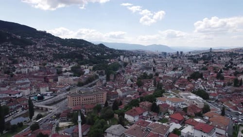 Aerial: Sarajevo cityscape with river, historic buildings, and hills