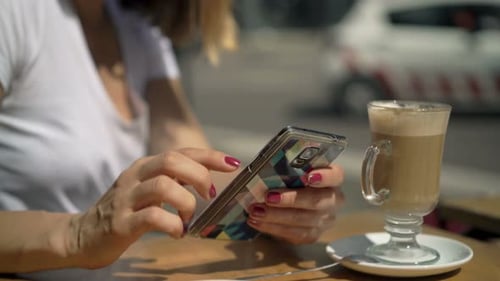 Woman Texting on Smartphone Sitting by Table in Cafe in City 30s