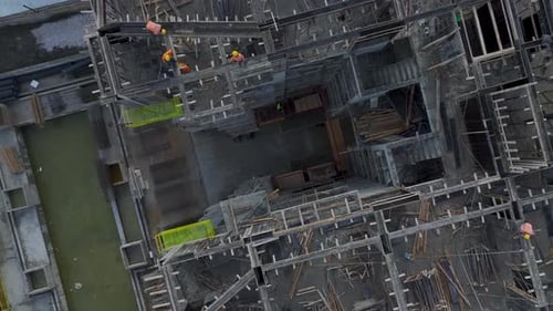 Aerial Video Aerial View of Construction Site Activities Including Metalwork and Floor Preparations