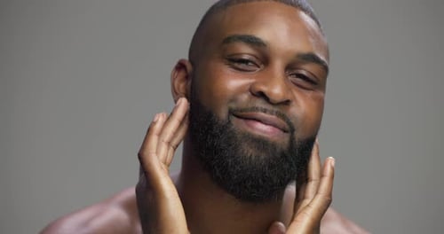Studio, black man and face with hands for skincare, hygiene and model with confidence for wellness