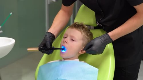 Dentist Orthodontist Operating with Blue Whitening Uv Lamp Curing Teeth Dental Care Concept