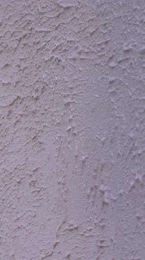 Paint Roller Applies Paint to Textured Wall
