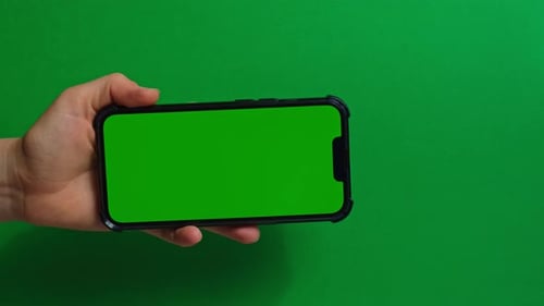 Hands Holding Cell Phone with Green Screen on Green Background