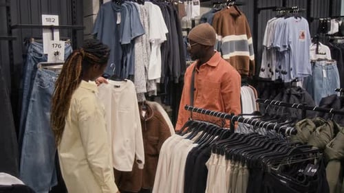 Clothes Sales Assistant Consulting Customer on Longsleeve in Shop
