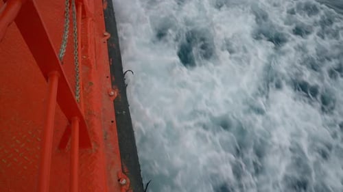 Barco rojo moviéndose por el mar frío