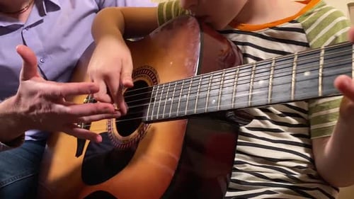 Father Teaching Son Guitar at Home