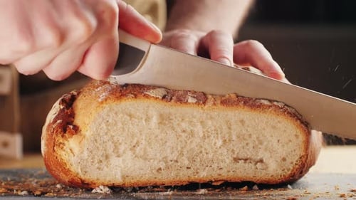 Close Up Slicing Fresh Baked Bread with Knife