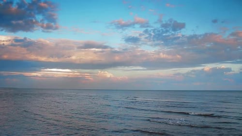 Sunset Beach with Tranquil Ocean Waves Pinkblue Sky Gentle Sea Ripples Reflect Dusk Light Serene