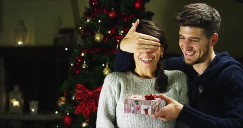 Happy Couple Exchanging Christmas Gifts at Home