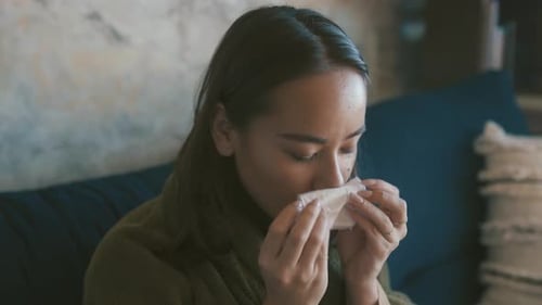 Woman Wipes Her Nose with Tissue Indoors