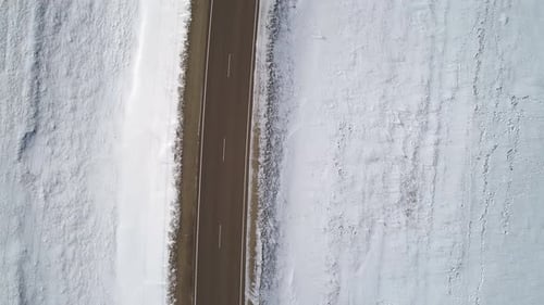 Aerial Top Down View on a Road Between the White Snowy Fields Beautiful Winter Landscape