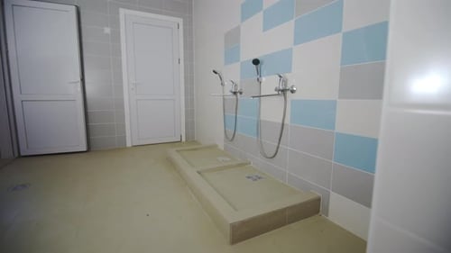 Public Shower Room with Tiles of Pale Colors in Gym