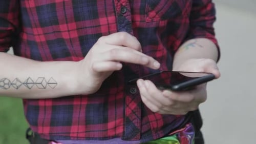 Close up shot of a young person texting and typing on their phone.