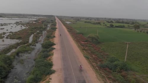 Aerial drone shot over main highway with left side of farmland fully submerged under water by severe
