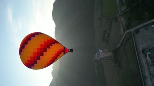 Hot air balloon epic flying above mountain over the fog at sunrise with beautiful sky