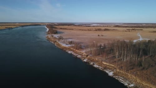 Top view of river and yellow field with snow