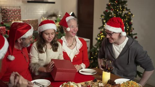 Family Gathering at Christmas Table Opening Gifts