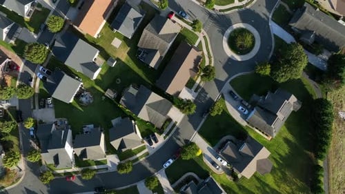 Vista aérea de arriba hacia abajo de un barrio americano con casas modernas y techo gris. Rotonda con