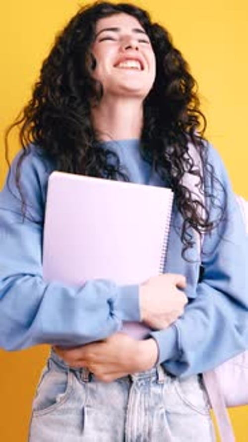 Smiling Young Woman with Notebook Posing in Studio