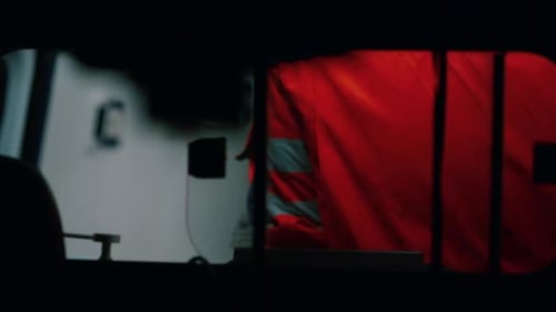 Unrecognizable paramedic standing in ambulance emergency vehicle at night