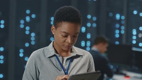 Woman Using Tablet in Server Room, Smiling