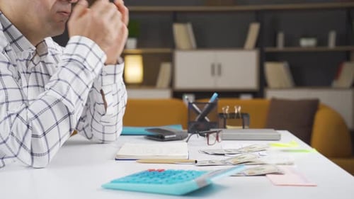 Stressed Man with Money at Home
