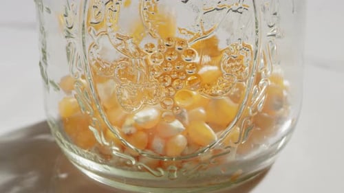 corn kernels filling up a mason jar