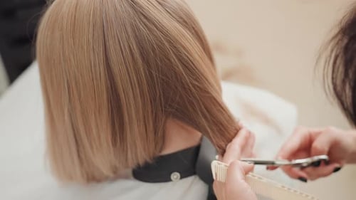 Woman getting blonde bob haircut in a salon