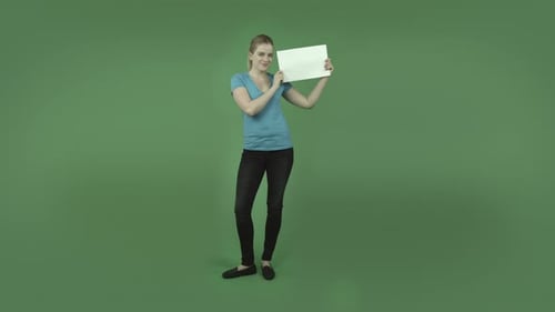 caucasian casual blond girl isolated on green happy with blank sign