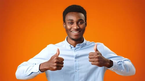 Young Adult Giving Thumbs Up on Orange Background