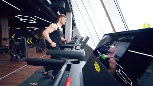 Fitness man training cardio exercise. Runner man training on treadmill machine in fitness center