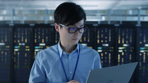 In the Modern Data Center: Portrait of IT Engineer Walking away from Server Racks, Finishing Maint