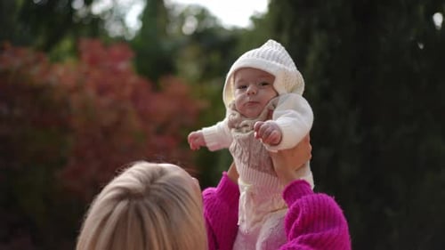 Mother Plays With Baby Outside in Fall
