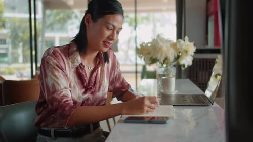 Portrait of Cheerful Businesswoman Writing in Planner