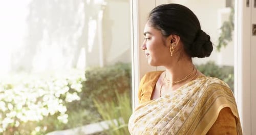 Mujer india sonriente en sari indio tradicional de pie junto a la ventana, con aspecto seguro, espacio para copiar