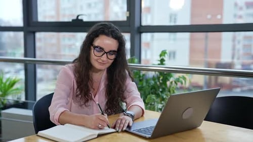 Young pretty business lady working with computer. Businesswoman in glasses working.