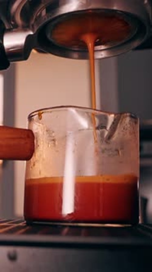 Coffee Being Poured from Espresso Machine into Glass