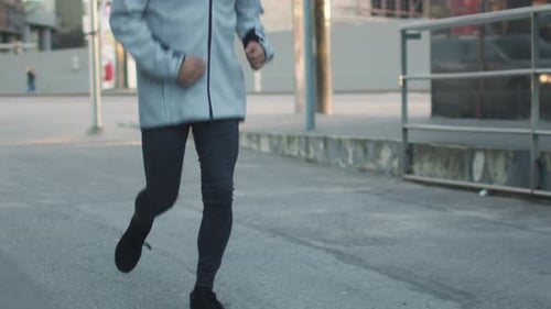 Young Adult Running in City on Sidewalk