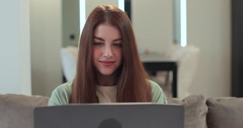 Woman Works on Laptop Computer at Home