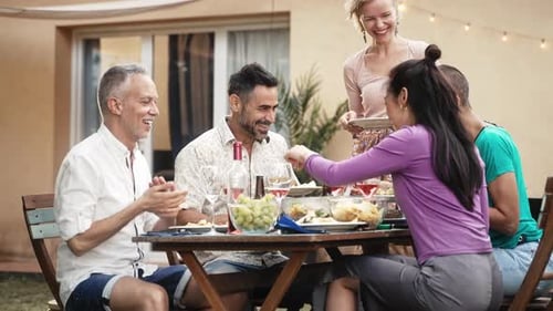 Mature Friends Sharing Good Times Talking at Garden Party Sitting at Table Talking Enjoying Summer