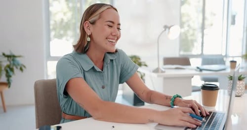 Cheerful Young Woman Working at Laptop in Office