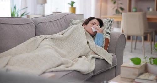 Woman Lying on Couch Suffering From a Cold