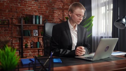Woman Typing on Laptop in Modern Office
