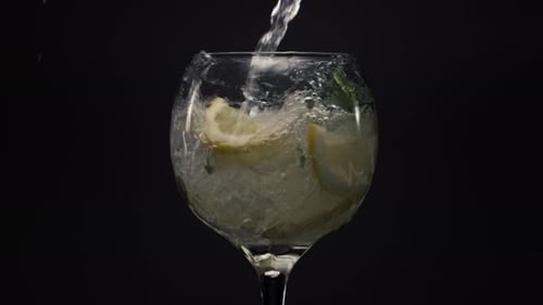 Refreshing drink is poured into glass with ice