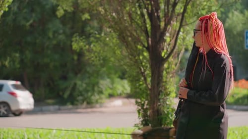 Woman with braided hair standing in park