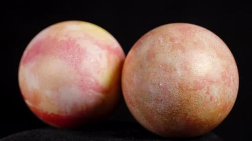 Two marbled pink-yellow Easter eggs are placed side by side, creating a beautiful contrast