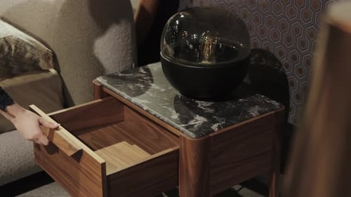 Woman opens drawer in stylish nightstand